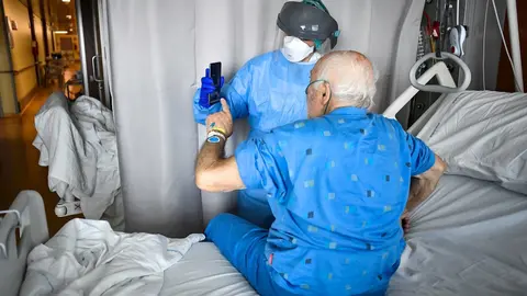 03 April 2020, Italy, Bergamo: A medic holds up a phone for a coronavirus patient to make a video call with a relative at the Papa Giovanni XXIII hospital. Photo: Claudio Furlan/LaPresse via ZUMA Press/dpa