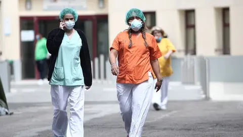 Dos sanitarias protegidas con mascarilla y gorro caminan cerca del Hospital de campa&ntilde;a en las inmediaciones de las Urgencias del Gregorio Mara&ntilde;&oacute;n para la lucha contra el coronavirus, en Madrid (Espa&ntilde;a) a 6 de abril de 2020.