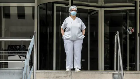 Sanitaria protegida con mascarilla y gorro durante el minuto de silencio en la entrada del Hospital Doctor Peset por la t&eacute;cnica de enfermer&iacute;a fallecida por coronavirus, en Valencia/Comunidad Valenciana (Espa&ntilde;a) a 6 de abril de 2020.