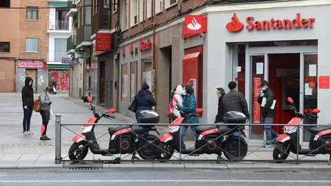 Varias personas esperan para entrar a una oficina del Banco Santander durante el inicio de la cuarta semana del estado de alarma decretado a consecuencia del coronavirus. En Madrid (Espa&ntilde;a), a 6 de abril de 2020.