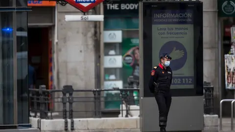 Un Polic&iacute;a Militar de la Guardia Real con mascarilla vigila la Puerta del Sol de la capital durante una Semana Santa at&iacute;pica en la que prosigue el estado de alarma decretado por el Gobierno para la lucha contra el coronavirus en Madrid. 8 de abril de 2020