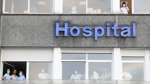 Varias sanitarias se asoman a las ventanas del Hospital Donostia durante el homenaje al personal sanitario realizado por de Bomberos, Ertzaintza, Guardia Municipal, Dbus, Cruz Roja, DYA, Consejo Sanitario de Osakidetza, ambulancias, y Correos, entre otros