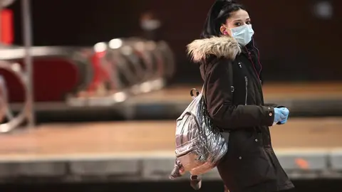 Viajeros esperan en uno de los andenes de Atocha donde la polic&iacute;a est&aacute; entregando mascarillas a los usuarios de transporte p&uacute;blico durante el segundo d&iacute;a de reparto de mascarillas en el transporte p&uacute;blico.