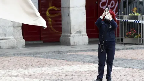 Una mujer hace una foto con su m&oacute;vil en la Plaza Mayor de Madrid durante el primer d&iacute;a de la cuarta semana de estado de alarma decretado por el Gobierno para combatir el coronavirus