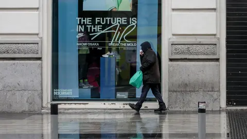 Una persona camina por una calle de Madrid donde las temperaturas han bajado estrepitosamente durante el segundo d&iacute;a de la entrada en vigor de la limitaci&oacute;n total de movimientos salvo de los trabajadores de actividades esenciales, medida adoptada ayer por