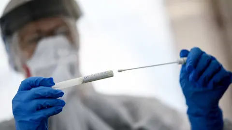 23 April 2020, Berlin: A staff member from the public health department in Mitte holds a swab tool in her hand at a drive-in coronavirus test station on the central fairground, amid the coronavirus outbreak. Photo: Britta Pedersen/dpa-Zentralbild/dpa