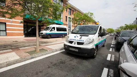 Una ambulancia con un lazo negro en el cap&oacute; pasa al lado de la Residencia Caser Residencial Alto del Prado, en la que trabajaba el empleado que falleci&oacute; ayer a consecuencia del COVID-19, y donde se ha realizado un homenaje en su recuerdo. Los sindicatos E