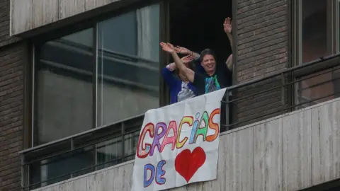 Dos vecinas sacan una pancarta en su casa como muestra de agradecimiento al personal sanitario que trabaja a destajo en la crisis del coronavirus  