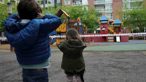 Un ni&ntilde;o y una ni&ntilde;a frente a un parque infantil clausurado, el primer d&iacute;a en el que los menores de 14 a&ntilde;os pueden salir a la calle, en Bilbao (Pa&iacute;s Vasco/Espa&ntilde;a) a 26 de abril de 2020.