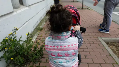 Una ni&ntilde;a pasea por la calle empujando un carrito con un beb&eacute; de juguete junto a su padre y su hermano durante el segundo d&iacute;a de desconfinamiento de ni&ntilde;os. En Madrid (Espa&ntilde;a) a 27 de abril de 2020.
