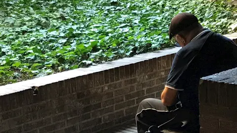 Una persona mayor descansa en un banco de la calle (Imagen de archivo)