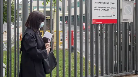 Una abogada vestida con toga y mascarilla entra a los Juzgados de lo Penal, Juzgados de Violencia sobre la mujer situados en la C/Albarrac&iacute;n, 31 de Madrid (Espa&ntilde;a), durante la semana siete del estado de alarma, cuando la violencia dom&eacute;stica sigue agrav&aacute;nd