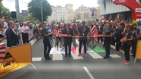 El alcalde de Bilbao, Juan Mari Aburto, corta la cinta para dar inicio a la decimotercera etapa de la Vuelta 2019 desde los alrededores del estadio San Mam&eacute;s