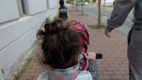 Dos ni&ntilde;os pasean por la calle junto a su padre durante el segundo d&iacute;a de desconfinamiento. En Madrid (Espa&ntilde;a) a 27 de abril de 2020.