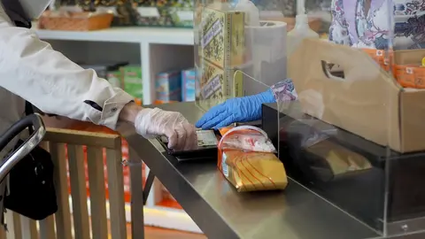 Una persona es atendida por una trabajadora de una farmacia de Vitoria, durante el d&iacute;a 46 de estado de alarma por la crisis del Covid-19, donde los movimientos est&aacute;n permitidos tan solo a menores de 14 a&ntilde;os, personas que no puedan teletrabajar o todos aqu