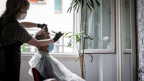 Un hombre se corta el pelo en una peluquer&iacute;a en el d&iacute;a en que estos locales pueden atender con cita previa y con limitaci&oacute;n de aforo dentro de la primera fase de desescalada, en Vitoria / &Aacute;lava / Pa&iacute;s Vasco (Espa&ntilde;a), a 2 de mayo de 2020.