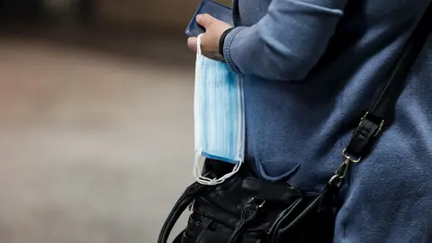 Una mujer porta una mascarilla en una mano en la estaci&oacute;n de metro de Sol durante la fase 0 de la desescalada del Gobierno en el inicio de la semana 8 del estado de alarma decretado por el coronavirus. En Madrid (Espa&ntilde;a), a 4 de mayo de 2020.
