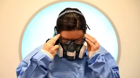 05 May 2020, England, Cambridge: A&nbsp;medic puts on Personal Protective Equipment (PPE) before working with Coronavirus patients in the intensive care unit at the Royal Papworth Hospital. Photo: Neil Hall/PA Wire/dpa