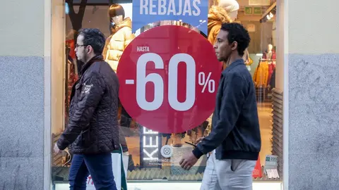Dos hombres pasean junto a una tienda de moda de Madrid