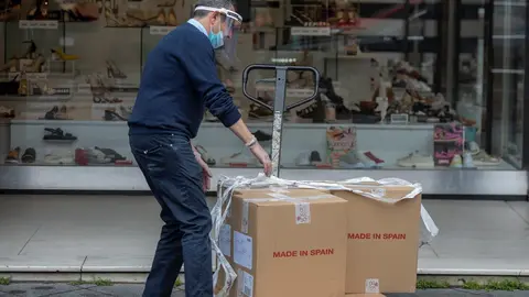 Un trabajador descarga mercanc&iacute;a en una zapater&iacute;a. Archivo  