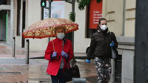 Dos mujeres pasean en la capital en un d&iacute;a de lluvia y bajada de temperaturas en toda Espa&ntilde;a, en que en gran parte de la Pen&iacute;nsula y Baleares se espera nubosidad, con chubascos y tormentas casi generalizados, que podr&aacute;n ser localmente fuertes o persistent