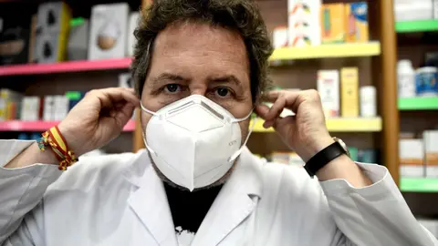 Un farmac&eacute;utico se coloca una de las siete millones de mascarillas FFP2 modelo KN95 que a partir de hoy las farmacias reparten gratuitamente entre la poblaci&oacute;n de la Comunidad de Madrid. En Madrid (Espa&ntilde;a), a 11 de mayo de 2020.