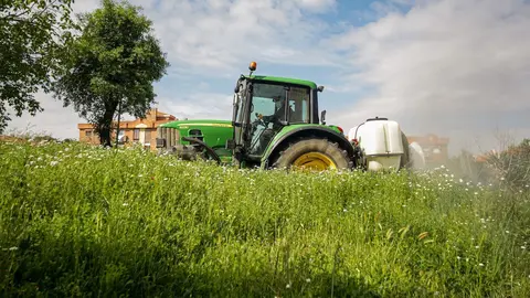 Un agricultor montado en su tractor.