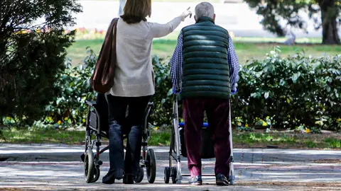 Un anciano y una mujer en el primer d&iacute;a en que los espa&ntilde;oles pueden salir de casa a pasear y hacer ejercicio al aire libre, pero solo en determinadas franjas horarias, divididos por edades.