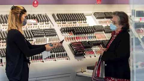 Una empleada de una tienda de cosm&eacute;tica atiende a una clienta