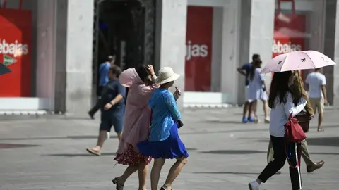 Turistas caminado en un d&iacute;a soleado en el centro de Madrid