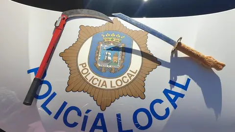 Espada-catana de 28 cm y hoz plegable de 23 cm que un conductor llevaba ocultas bajo su asiento y en el maletero