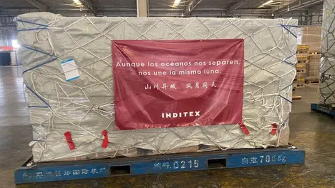 Paquete en un carguero preparado para ser enviado en el que se lee 'Aunque los oc&eacute;anos nos separen, nos une la misma luna'. Este es uno de los paquetes que incluyen algunas de las 300.000 mascarillas donadas por Inditex que llegar&aacute;n a Espa&ntilde;a desde China e