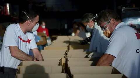 Voluntarios de Cruz Roja preparan lotes de comida