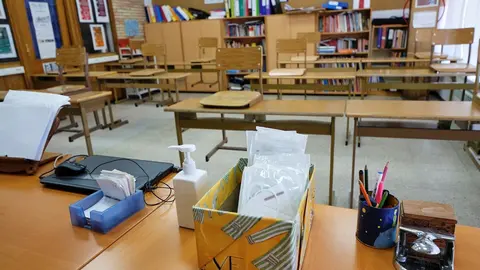 Mascarillas y gel desinfectante en la mesa del profesor de un aula.