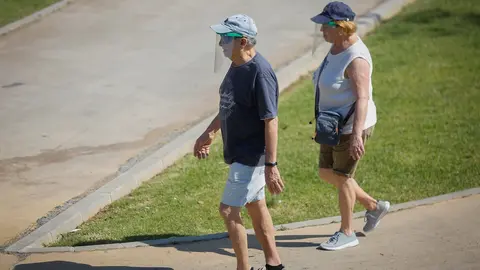 Dos personas con ropa veraniega y gorra pasean por el parque del Alamillo. En Sevilla (Andaluc&iacute;a, Espa&ntilde;a), a 21 de mayo de 2020.