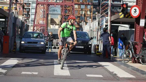 Un ciclista y dos coches cruzan el Puente de Vizcaya