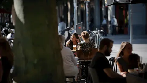 Varias personas disfrutan en la terraza de un bar durante el segundo d&iacute;a de la reapertura al p&uacute;blico de las terrazas al aire libre de los establecimientos de hosteler&iacute;a y restauraci&oacute;n. En Barcelona, Catalunya (Espa&ntilde;a) a 26 de mayo de 2020.