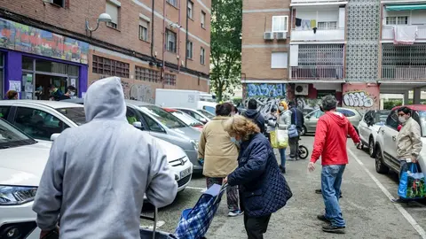 Vecinos realizan una cola para recoger bolsas de la Asociaci&oacute;n de Vecinos Parque Aluche. En Aluche, Madrid, (Espa&ntilde;a), a 16 de mayo de 2020.