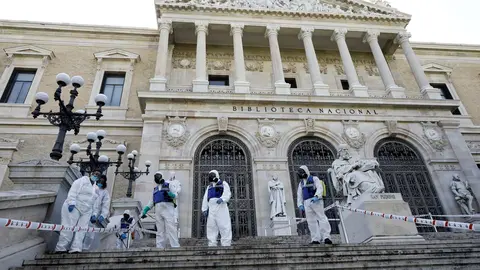 Agentes de la UME con mochilas nebulizadoras en la desinfecci&oacute;n de las escaleras de la entrada de la Biblioteca Nacional
