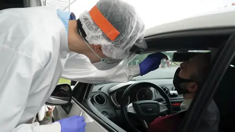 Un trabajador sanitario le realiza un test desde un veh&iacute;culo a un hombre, en la zona habilitada en el Hospital de Basurto en Bilbao, donde la consejera de Salud de Euskadi, Nekane Murga, confirm&oacute; ayer que se detectaron diez positivos en COVID-19, ocho de 