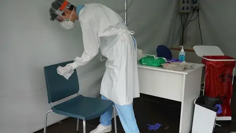 Un trabajador sanitario desinfecta una de las sillas utilizadas por un paciente para realizarse un test de Covid-19 en la zona habilitada en el Hospital de Basurto en Bilbao