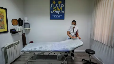 Una fisioterapeuta ciega de la Cl&iacute;nica Fisio SM Terapia (calle Covarrubias, 35) prepara la camilla de un paciente en el primer d&iacute;a de la fase 1 de la desescalada en Madrid. En Madrid (Espa&ntilde;a), a 25 de mayo de 2020.