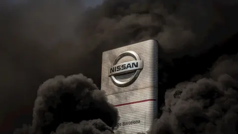 Trabajadores de la planta de producci&oacute;n de Nissan en Barcelona queman neum&aacute;ticos en el exterior de la f&aacute;brica en la Zona Franca el d&iacute;a en el que fabricante japon&eacute;s de autom&oacute;viles, como parte de su nuevo plan estrat&eacute;gico a medio plazo, ha decidido cerrarla
