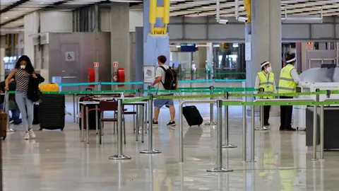 Pasajeros procedentes de Londres caminan entre los pasillos delimitados, antes de rellenar un formulario, a su llegada al Aeropuerto de Madrid-Barajas Adolfo Su&aacute;rez, como medida de control de los casos sospechosos de coronavirus cuatro d&iacute;as despu&eacute;s desde 