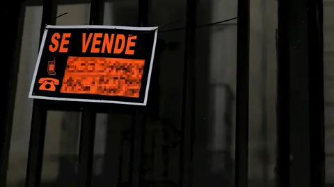 Cartel colgado en un edificio que indica que el inmueble est&aacute; en venta