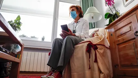 Araceli, usuaria de aud&iacute;fonos intracanales y miembro de FIAPAS (Confederaci&oacute;n Espa&ntilde;ola de Familias de Personas Sordas), observa su tel&eacute;fono m&oacute;vil desde el sal&oacute;n de su domicilio, durante la fase 2 de la desescalada.
