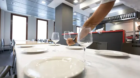 Un camarero coloca un vaso 