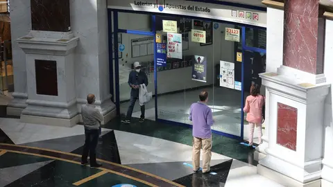 Varias personas hacen cola para entrar en una administraci&oacute;n de Loter&iacute;a del Centro Plaza Norte 2, La C&uacute;pula de Madrid, durante el segundo d&iacute;a de la Fase 2 de desescalada, y un d&iacute;a despu&eacute;s de reanudar su actividad puesto que se permite la reapertura de cen