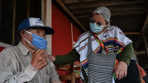 Una enfermera revisa a un hombre de origen ind&iacute;genas en Suba, Bogot&aacute;, durante la pandemia de COVID-19.