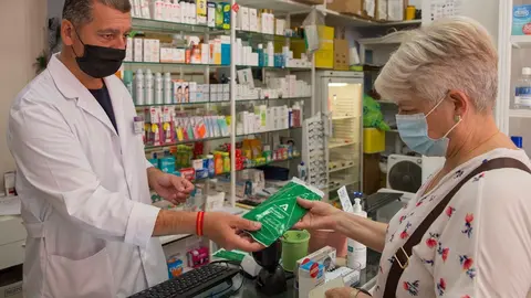 Una mujer adquiere las mascarillas gratuitas que la Junta de Andaluc&iacute;a en una imagen de archivo.